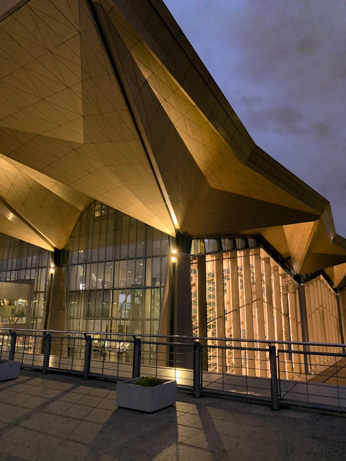 Crafting Captivating Headlines: Your awesome post title goes here Illuminated modern building facade at twilight showcasing unique geometric design.